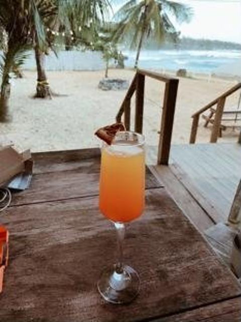 Cóctel tropical sobre la mesa de madera frente al mar
