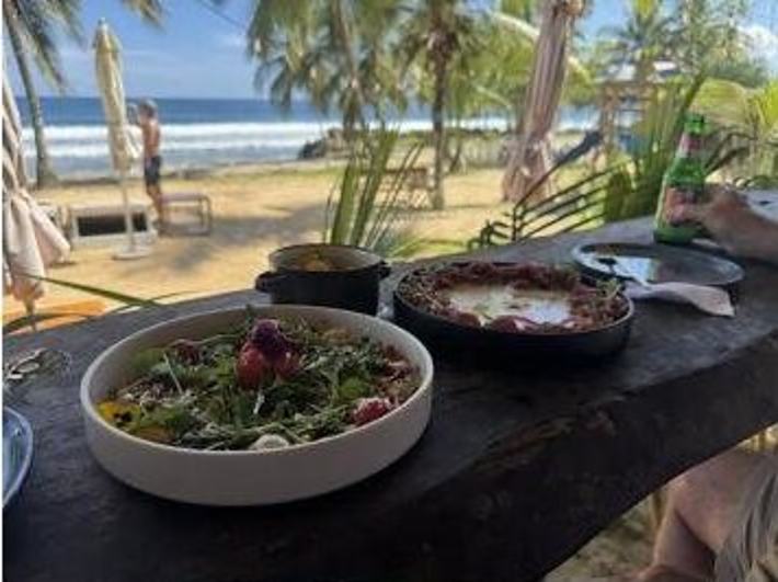 Mesa servida con vista a la playa y las sombrillas